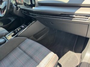 Innenraum eines Autos mit grauen Sitzen in kariertem Muster und einem modernen Armaturenbrett.