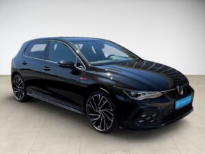 Schwarzer Sportwagen mit modernem Design, geöffnete Motorhaube, steht auf hellbraunem Boden.
