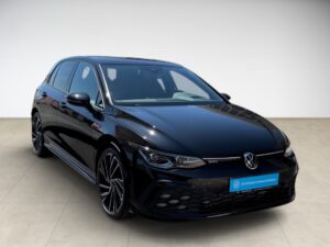 Schwarzer Volkswagen Golf GTI, glänzend, Frontansicht auf hellem Boden.