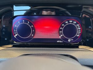 Digitales Armaturenbrett mit Tachometer, rot-schwarze Farben, futuristisches Design.