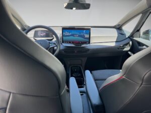 Innenraum eines modernen Autos mit grauen und schwarzen Sitzen und großem Bildschirm in der Mitte.