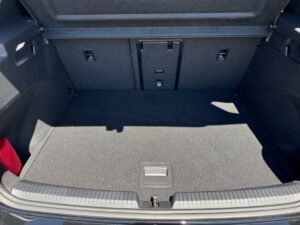 Kofferraum eines Autos mit umgelegter Rückbank, leer und sauber, helle Teppichfläche.