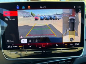 Bildschirm zeigt Rückfahrkamera eines Autos mit Parkassistent und Klimasteuerung bei 26,5°C.
