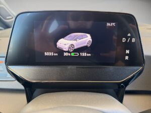 Digitalanzeige eines Autos zeigt 30 % Ladung, 5035 km Reichweite und 26,5 °C, mit Autoabbildung.