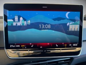 Farbdisplay im Auto zeigt eine nächtliche Landschaft mit Uhrzeit und Datum an.