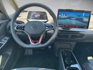 Innenansicht eines Volkswagen-Autos mit Lenkrad und großem Touchscreen-Display.