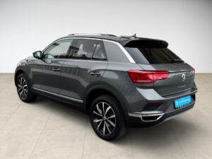 Graues SUV auf hellem Boden, seitliche Heckansicht, moderne schwarze Felgen, glänzende Lackierung.