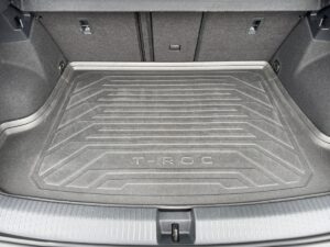 Kofferraum eines Autos mit grauer Gummimatte, Aufschrift T-Roc, sauber und geräumig.