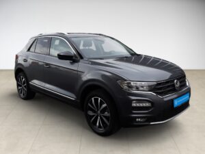 SUV in Dunkelgrau mit glänzenden schwarzen Felgen und markantem Markenemblem vorne.