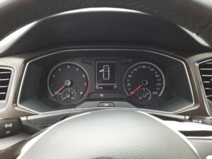 Armaturenbrett eines Autos mit Tachometer, Drehzahlmesser und Anzeige auf schwarzem Hintergrund.