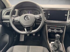 Ansicht des Innenraums eines Autos mit Lenkrad und Armaturenbrett in Schwarz und Grau.