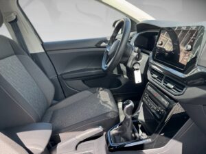 Fahrzeuginnenraum mit grauen Sitzen, schwarzem Armaturenbrett und großem Touchscreen. Modernes Design.