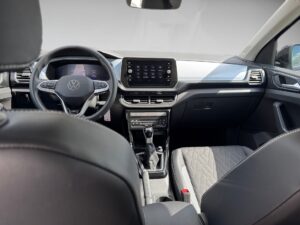 Innenraum eines Volkswagen mit schickem Armaturenbrett und modernem Display, schwarz-graue Sitze.