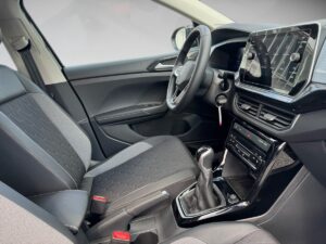Innenraum eines modernen Autos mit grauen Sitzen, großem Touchscreen und manuellem Schalthebel.