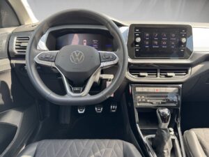 Innenraum eines Autos mit Volkswagen-Lenkrad und Infotainment-Bildschirm.