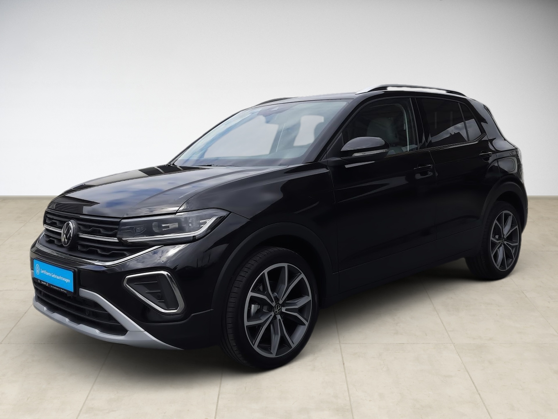 Schwarzer SUV mit modernen Scheinwerfern und großen Felgen, steht auf hellem Boden.