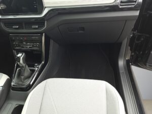 Innenraum eines Autos, Blick auf den Beifahrersitz, dunkles Armaturenbrett, heller Sitzbezug.