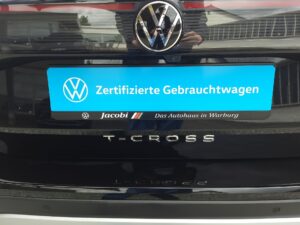 Nahaufnahme eines schwarzen Volkswagen mit einem Schild "Zertifizierte Gebrauchtwagen" hinten.