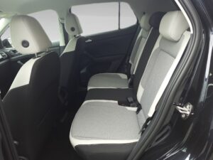 Rücksitz eines Autos mit grauen Polstern, schwarze und weiße Details, moderne und elegante Ausstattung.
