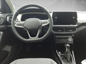 Lenkrad eines modernen VW-Autos mit digitalem Display und Schalthebel in Schwarz und Grau.