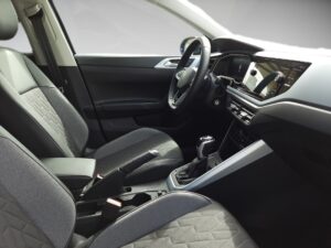 Innenraum eines Autos mit grauen Sitzen, modernem Lenkrad und einem Touchscreen-Display.