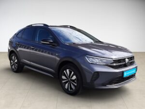 Graues Auto in Seitansicht, glänzend, modernes Design, mit markanten Felgen und geschlossener Umgebung.