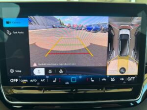 Bildschirm eines Parkassistenten, zeigt Rückfahrkamera und Vogelperspektive eines Autos.