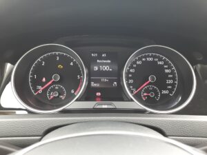 Das Armaturenbrett eines Autos zeigt Geschwindigkeit und Kraftstoffanzeige in Schwarz und Rot.