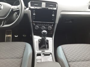 Innenansicht eines Autos mit manuellem Schaltgetriebe und schwarzer Konsole.