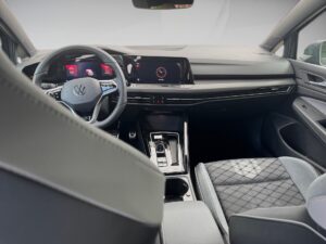 Innenraum eines modernen Autos mit grauen Ledersitzen und digitalem Armaturenbrett.