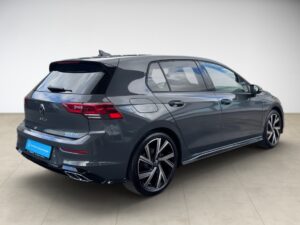 Graues Auto von schräg hinten, glänzend, klarer Himmel im Hintergrund, stilvolle Felgen.