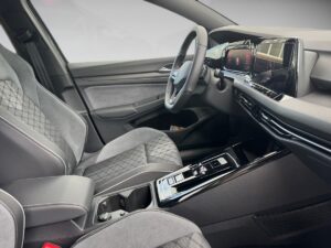 Innenraum eines modernen Autos, graue Sitze, schwarze Details, digitales Armaturenbrett, elegantes Design.