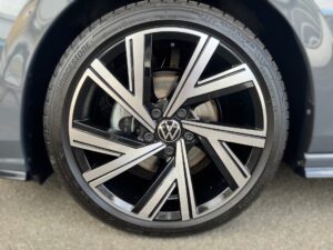 Nahaufnahme eines silbernen VW-Rads mit schwarz-silbernen Speichen auf einem Reifen.