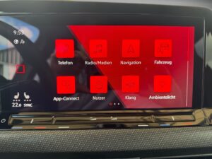 Ein Touchscreen-Autodisplay zeigt rote Menüsymbole auf schwarzem Hintergrund bei 22 Grad.
