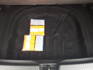Ein leerer Autokofferraum mit zwei Packungen reflektierender Warnwesten.