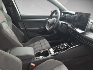 Der Innenraum eines Autos mit modernen, grauen Sitzen und einem großen Display am Armaturenbrett.
