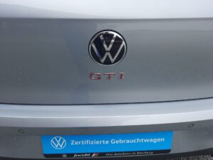 Silbernes Volkswagen Heck mit GTI-Emblem und blauem Schild: Zertifizierte Gebrauchtwagen.
