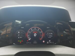 Digitales Armaturenbrett eines Autos, zeigt Geschwindigkeit 0 km/h, Temperatur 16 Grad, schwarz.