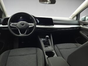 Modernes Auto-Interieur mit schwarzem Lenkrad, grauen Sitzen und digitalem Display.