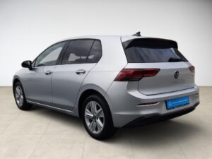Silberner VW Golf in hellem Raum, Seitenansicht, elegante Linien, moderne Rücklichter.