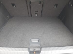 Kofferraum eines Autos mit umgeklapptem Rücksitz, grau, sauber, ohne Gegenstände oder Personen.
