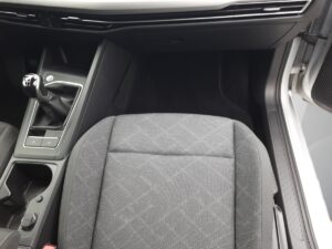 Innenraum eines Autos in Schwarz mit Schalthebel und Beifahrersitz in einem dezenten Muster.