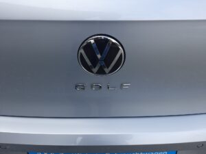 Volkswagen-Logo auf einem silbernen Autoheck mit dem Schriftzug Golf darunter.