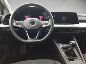 Modernes Autolenkrad und Armaturenbrett in Schwarz, zeigt Digitalanzeigen und manuelle Schaltung.