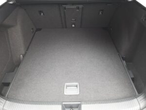 Ein leerer, grauer Kofferraum eines Autos mit sauberer Oberfläche und seitlichen Haken.