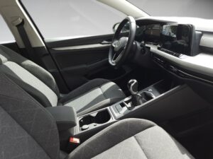 Moderner Auto-Innenraum, graue Sitze, schwarzes Lenkrad, digitales Display, angenehme Beleuchtung.