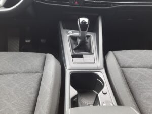 Schwarz-graue Auto-Mittelkonsole mit Schaltknüppel und Getränkehalter, modernes Design.