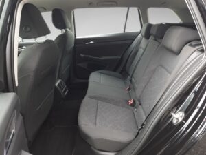 Schwarzes Auto, geräumiger Rücksitz mit grauen Stoffbezügen, seitlich fotografiert.
