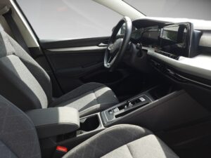 Innenansicht eines Autos mit grauen Sitzen, Lenkrad und moderner Armaturentafel.