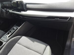 Modernes Auto-Armaturenbrett in Grau mit digitalem Display und stilvollen Belüftungsöffnungen.
